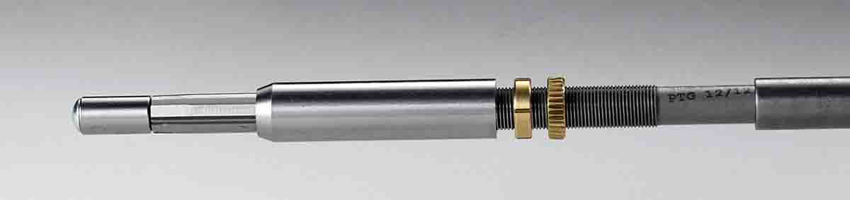 A sliding sleeve on the throating reamer shaft has a tapered section at the forward edge to mate with the cartridge’s shoulder angle. The forward reamer pilot and beveled edge of the sleeve keep the reamer centered in the rifle’s bore. The brass nut is marked in .005-inch adjustment increments and is locked in place with the rearward nut to control the sleeve position and throating depth.